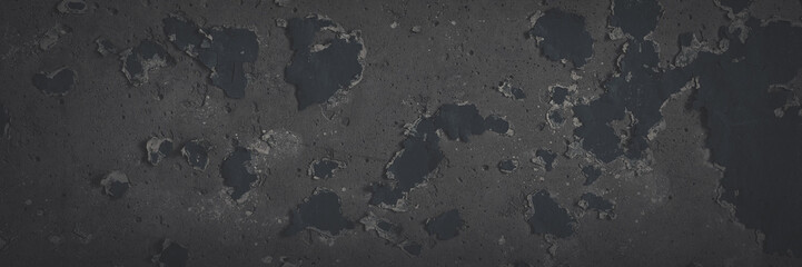 Dark wide panoramic background. Peeling paint on a concrete wall. Faded dark texture of old cracked flaking paint. Weathered rough painted surface with patterns of cracks. Shaded background for design
