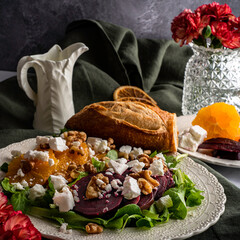 Beet salad with oranges, feta cheese, and toasted walnuts on a bed of mixed greens.