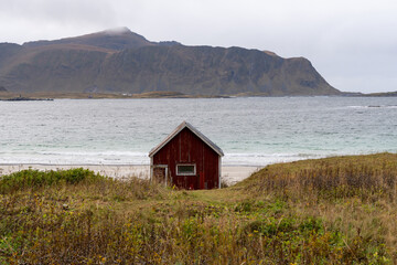 Red boathouse at Ramberg Beach in the Lofoten Islands, Norway