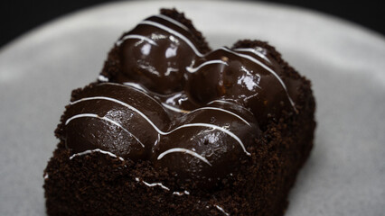 Cake with black profiteroles. Chocolate cake shot from above on white plate