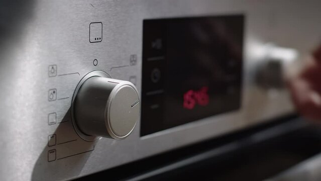 Home cooking - turning on an oven in a home kitchen. Low angle closeup shot.