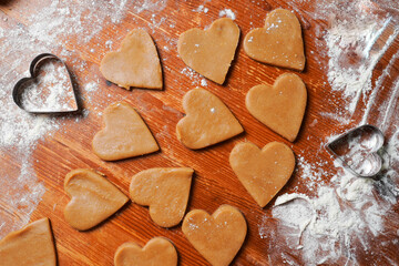 Heart cookies out dough and molds on table with flour. Valentines Day celebration. Home baking.