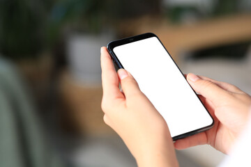 Closeup view of woman with smartphone indoors. Space for text