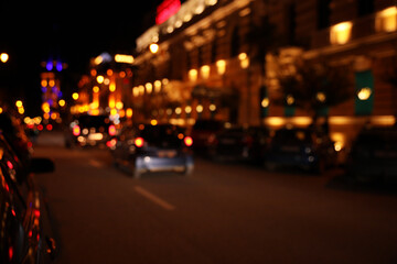 Fototapeta na wymiar Blurred view of city street with lights at night. Bokeh effect