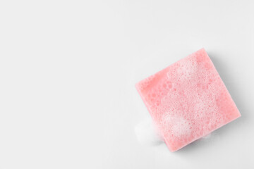 Soap with fluffy foam on white background, top view