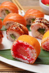 Different delicious sushi rolls on white plate, closeup