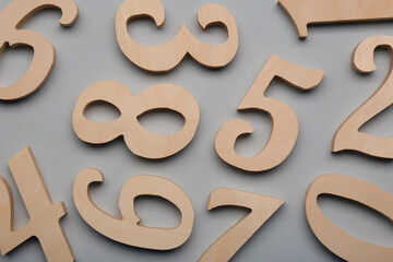 Wooden numbers on light grey background, flat lay