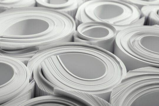 Rolled white paper sheets as background, closeup