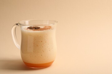 Delicious eggnog with anise on beige background. Space for text