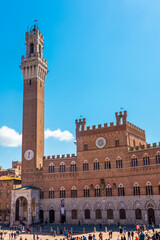 Fototapeta na wymiar Tourists enjoy Piazza del Campo square in Siena, Italy. The historic centre of Siena has been declared by UNESCO a World Heritage Site.