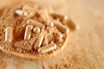 Guarana capsules in guarana powder in a wooden spoon.Supplements and vitamins. Healthy eating. sports nutrition.Transparent capsules with guarana powder.Alternative medicine 