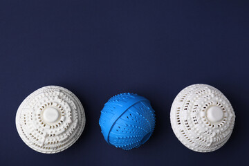 Laundry dryer balls on dark blue background, flat lay. Space for text