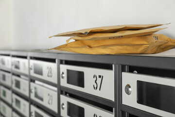 New mailboxes with keyholes, numbers, receipts and envelopes in post office, closeup