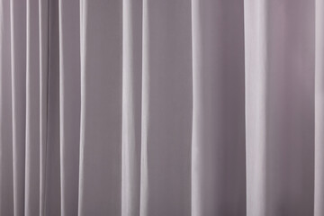 Beautiful light grey window curtains as background, closeup