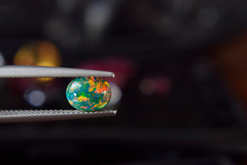 Opal is an iridescent opal. in the gem clamp