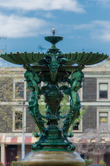 A classical patina fountain in Melbourne park with building