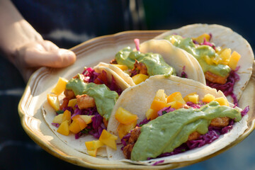 Woman holding a plate of home-made tacos