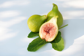 Freshly picked ripe organic Kadota figs and a fig leaf on white background