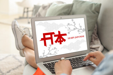 Young woman with laptop studying Japanese at home, closeup