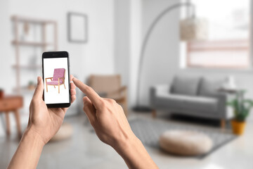 Woman with mobile phone buying online new armchair in furniture store at home