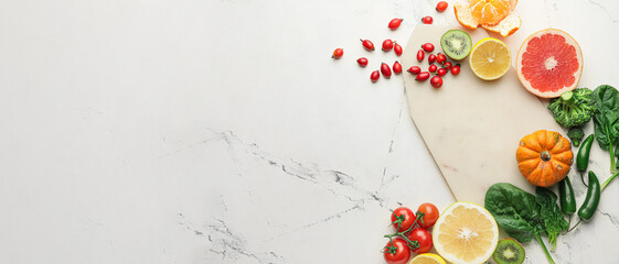 Empty board with healthy fresh fruits, vegetables and herbs on white background with space for text