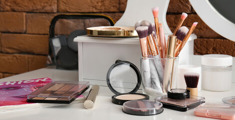 Fototapeta na wymiar Set of decorative cosmetics and makeup brushes on table