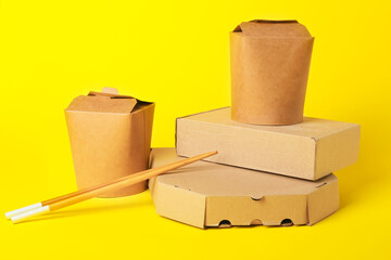 Different food boxes and chopsticks on color background