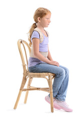 Little girl in back brace sitting on white background