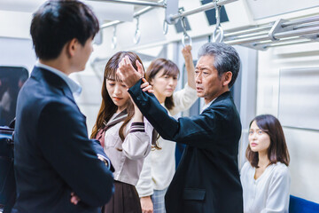 Obraz premium 電車内で取り押さえられる中年男性