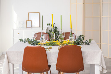 Table setting with candles and beautiful floral decor in light room