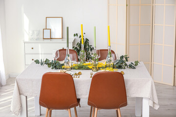 Table setting with candles and beautiful floral decor in light room