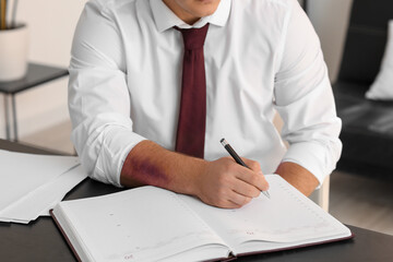 Man with bruise on arm working in office