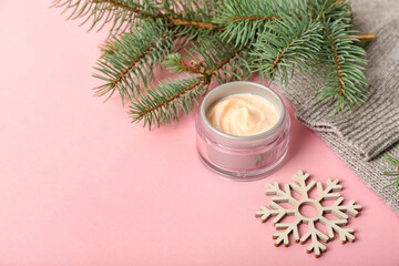 Jar of cream, fir branches and Christmas decor on pink background