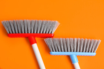 Brooms for cleaning on color background