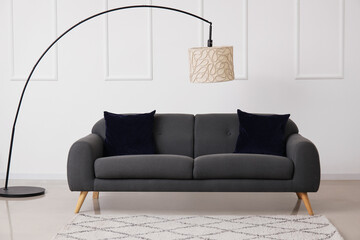 Interior of living room with black sofa and lamp