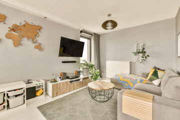 Naklejka premium a living room with a map on the wall and a grey couch, coffee table, planters, and tv