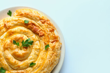 Plate with delicious cheese pie on blue background