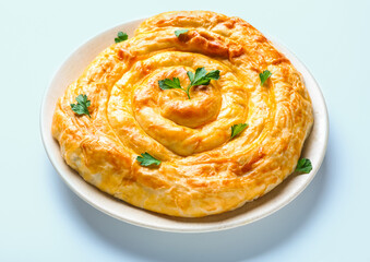 Plate with delicious cheese pie on blue background
