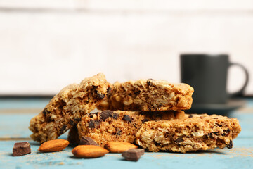 Tasty biscotti cookies, almond nuts, chocolate and cup on blue wooden table