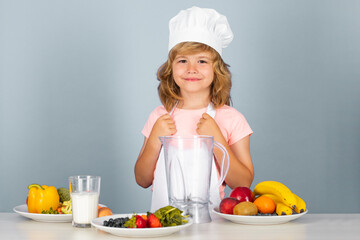 Child chef dressed cook baker apron and chef hat isolated on studio background. Healthy nutrition kids food. Fruits and vegetables for kids.