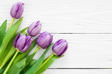 Bouquet of purple tulips, a bouquet of spring flowers on a white wooden background, flat lay, copy space.