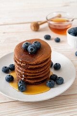 chocolate pancake stack with blueberry and honey