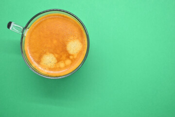 glass of hot black coffee put on green background