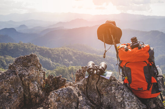 Backpack ,Camera,and hat on top rock mountain. Travel photos contributor concept.