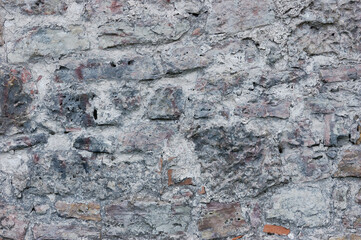 Stone wall background closeup, horizontal plastered grunge red grey beige stonewall limestone pattern, old aged weathered gray lime plaster texture natural grungy textured reddish vintage rough rustic