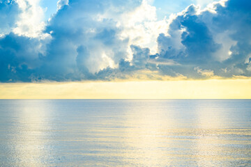 Sunset on tropical beach sea ocean with sunrise clouds. Banner for travel vacation. Scenery sky and reflection rays in water. Orange and golden sunset sky calmness tranquil sunlight summer mood.