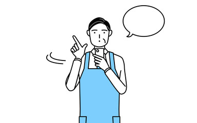 スマホを操作するエプロンを着たシニア男性