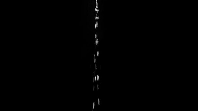 A thin jet of water from drops fall on a black background. Overlay template.