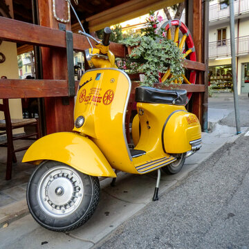 Gelbe Vespa Motorroller steht auf einem Restaurant in Lignano, Italien
