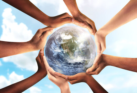 Conceptual symbol of multiracial human hands surrounding the Earth globe. Unity, world peace, humanity concept. World environment day- Earth Day concept. Elements of this image furnished by NASA.